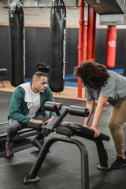 Client learning gym exercises with a personal trainer