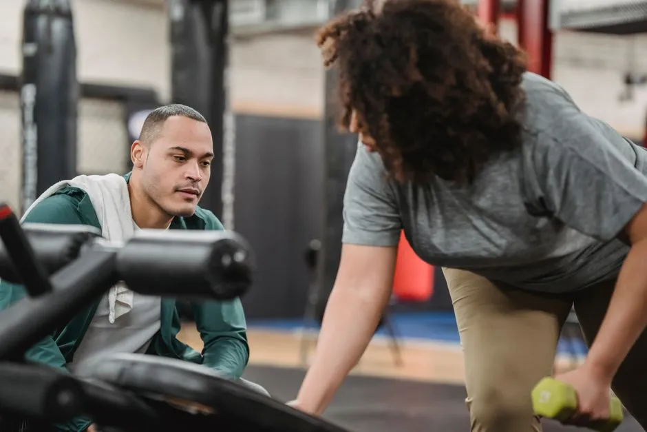 Client learning gym exercises with a personal trainer